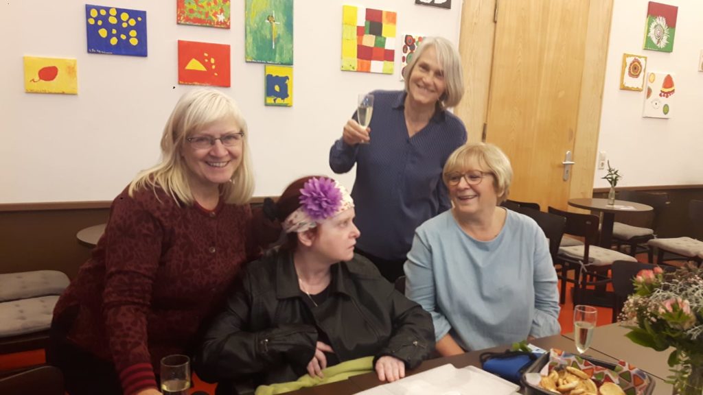 4 Personen vor einer Wand mit Bildern